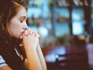 Struggling with alcohol addiction, woman praying for sobriety in a support environment.