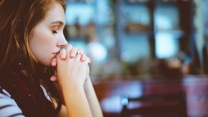 Struggling with alcohol addiction, woman praying for sobriety in a support environment.
