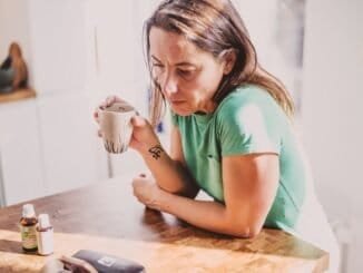 Woman holding a mug, contemplating sobriety, alcohol-free lifestyle, Deep Sober recovery support.