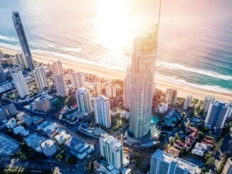 Stunning aerial view of a coastal city with skyscrapers and beach at sunset, promoting sobriety and wellness.