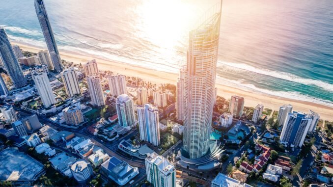 Stunning aerial view of a coastal city with skyscrapers and beach at sunset, promoting sobriety and wellness.