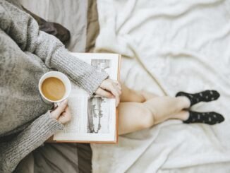 Calm person enjoying coffee and reading a book for sober lifestyle recovery.